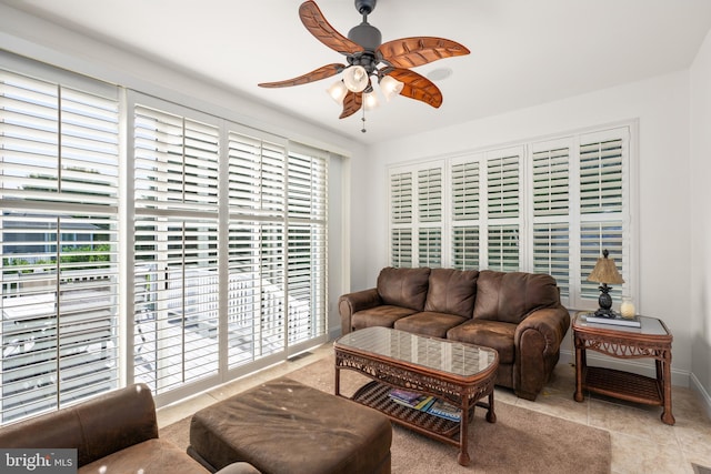 living room with a wealth of natural light, ceiling fan, and light tile patterned flooring