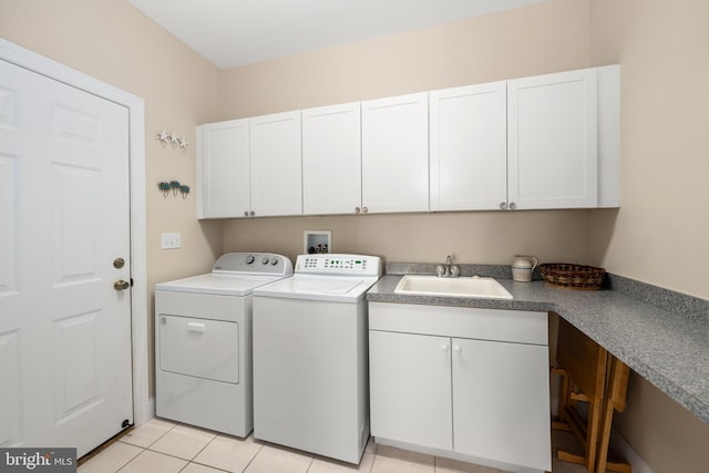 washroom with cabinets, sink, washer and dryer, and light tile patterned floors