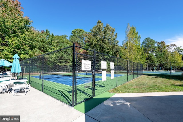 view of community featuring tennis court