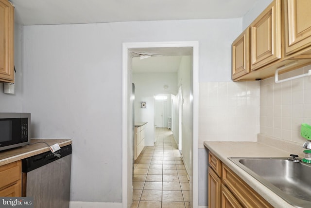 kitchen featuring light tile patterned floors, stainless steel appliances, backsplash, and sink