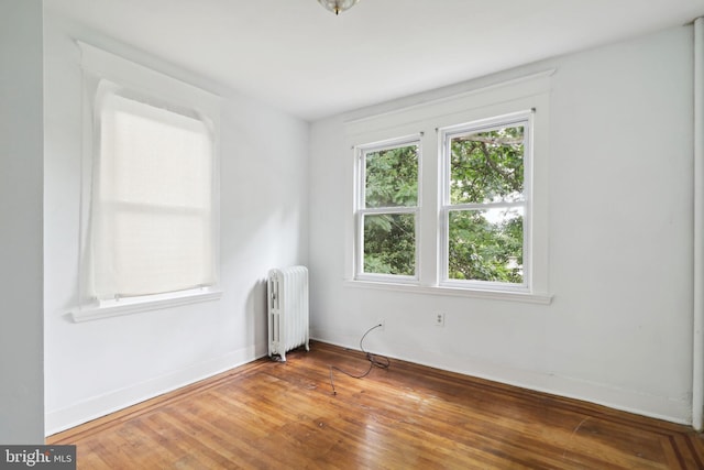 spare room with wood-type flooring and radiator