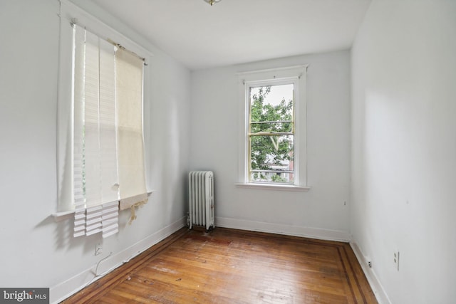 unfurnished room featuring radiator heating unit and wood-type flooring