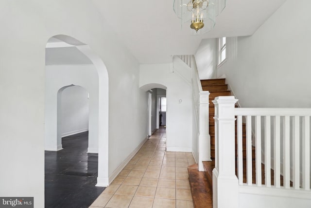 hall with a chandelier and light tile patterned flooring