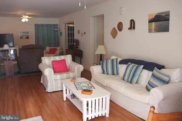 living area with wood finished floors and a ceiling fan