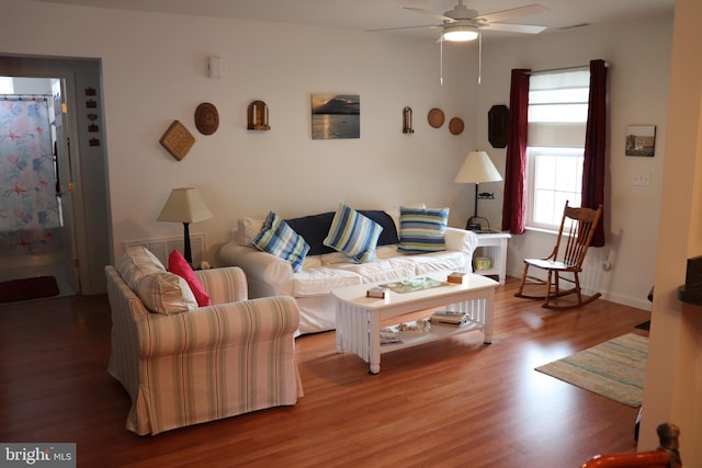 living area featuring a ceiling fan, wood finished floors, and baseboards