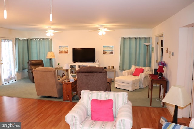 living area with wood finished floors and a ceiling fan