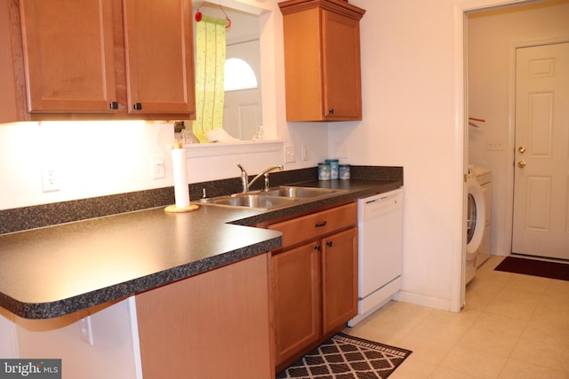 kitchen with a breakfast bar area, dishwasher, independent washer and dryer, kitchen peninsula, and sink