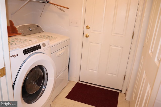 clothes washing area featuring washer and dryer and light tile patterned flooring