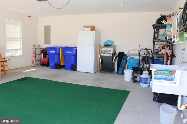 garage featuring electric panel, a garage door opener, and freestanding refrigerator