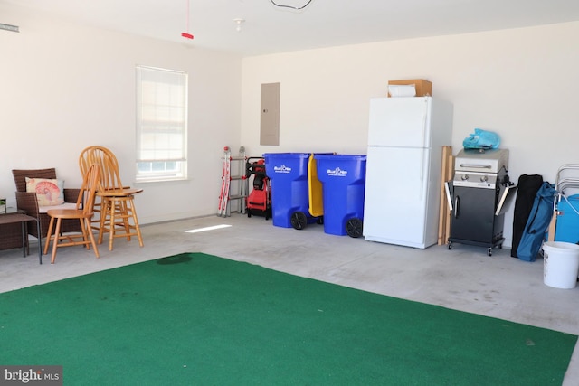 garage featuring electric panel and freestanding refrigerator