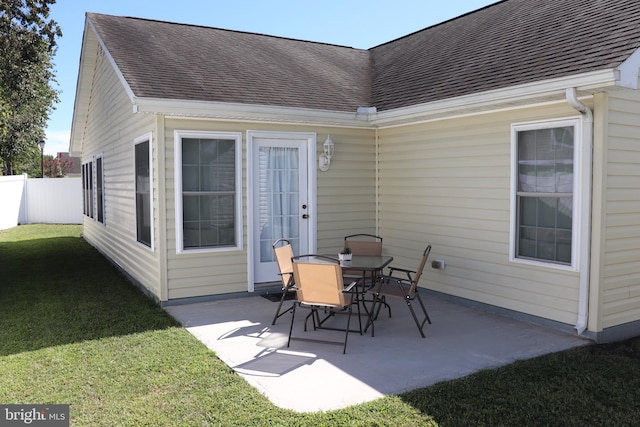 rear view of house with a lawn and a patio