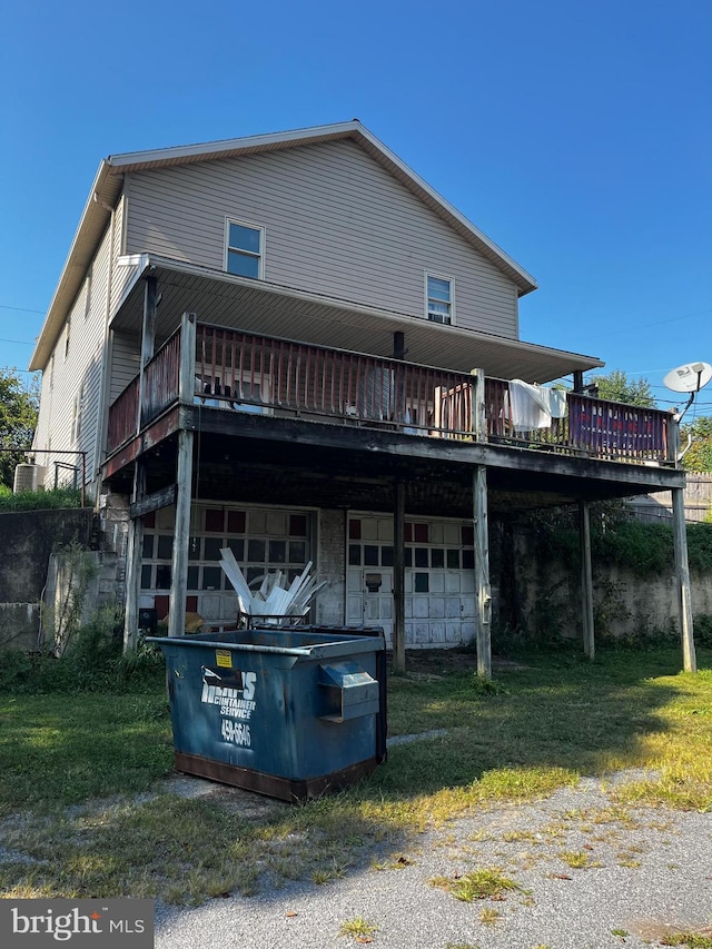 rear view of property with a wooden deck and an attached garage