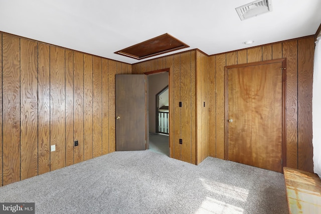 unfurnished bedroom with wooden walls and carpet