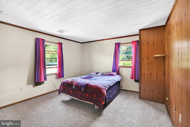 bedroom with wood walls, carpet, and ornamental molding