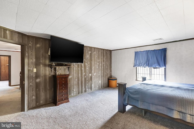 bedroom with ornamental molding, carpet floors, and wooden walls