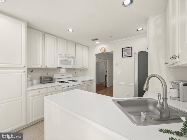 kitchen featuring white appliances, white cabinets, sink, and light tile patterned floors