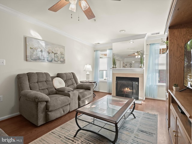 living room featuring wood-type flooring, plenty of natural light, and crown molding