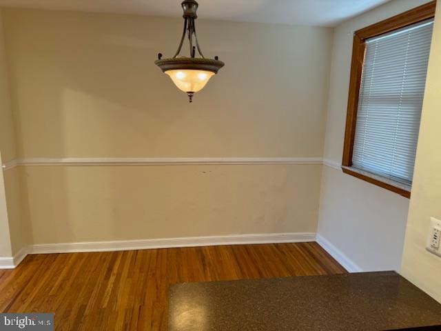 unfurnished dining area featuring dark wood-type flooring