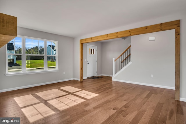 interior space featuring visible vents, baseboards, wood finished floors, and stairs