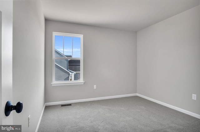 carpeted empty room featuring visible vents and baseboards