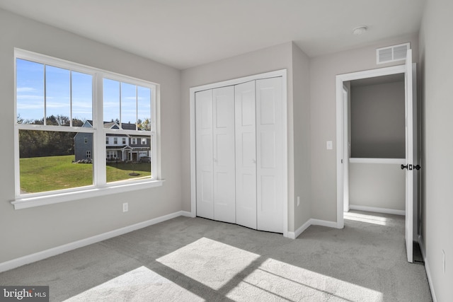 unfurnished bedroom with baseboards, visible vents, and carpet floors