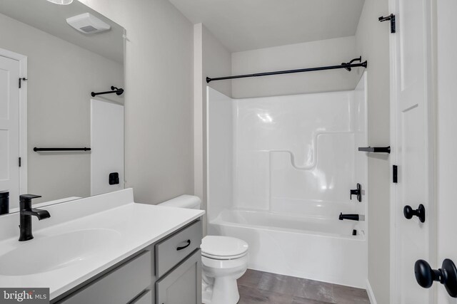 bathroom with bathtub / shower combination, toilet, and vanity