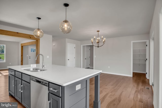 kitchen featuring a sink, gray cabinetry, light wood-type flooring, and stainless steel dishwasher