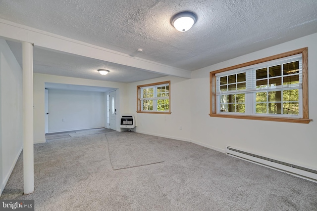 unfurnished living room with a wealth of natural light, a baseboard radiator, light colored carpet, and heating unit