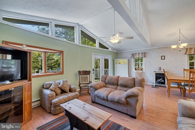 living room featuring lofted ceiling, a baseboard radiator, ceiling fan with notable chandelier, and hardwood / wood-style floors