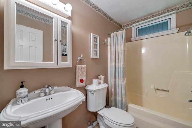 full bathroom featuring toilet, shower / tub combo, a textured ceiling, and sink