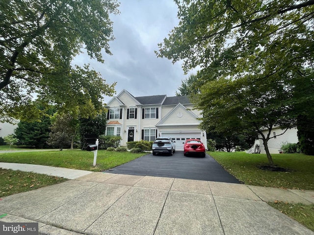 colonial inspired home with a garage, a front yard, and driveway