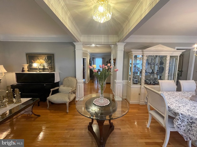 interior space with light wood-style flooring, ornate columns, and a chandelier