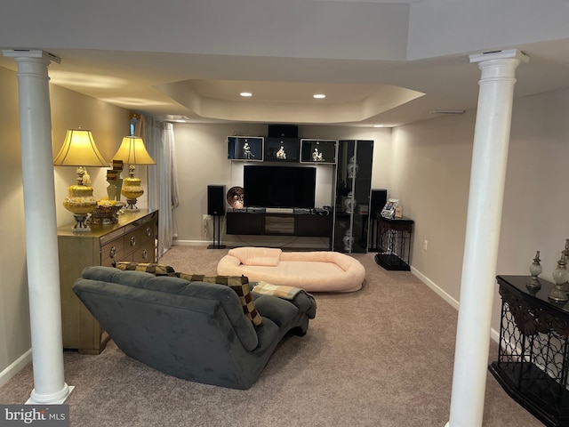 living area with a raised ceiling, decorative columns, carpet, and baseboards