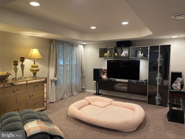 carpeted living area featuring a tray ceiling, recessed lighting, and baseboards