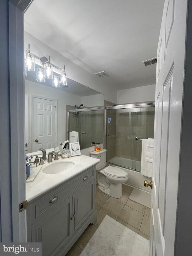 full bathroom featuring visible vents, toilet, tile patterned flooring, enclosed tub / shower combo, and vanity