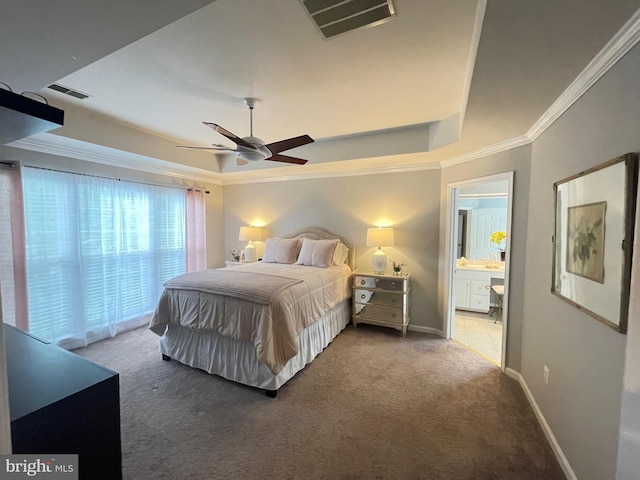 bedroom featuring visible vents, a tray ceiling, carpet, crown molding, and baseboards