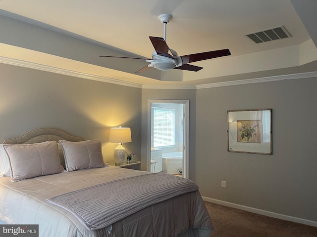 carpeted bedroom featuring visible vents, connected bathroom, baseboards, ornamental molding, and a raised ceiling