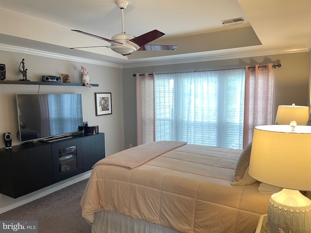 carpeted bedroom featuring visible vents, crown molding, a raised ceiling, and a ceiling fan