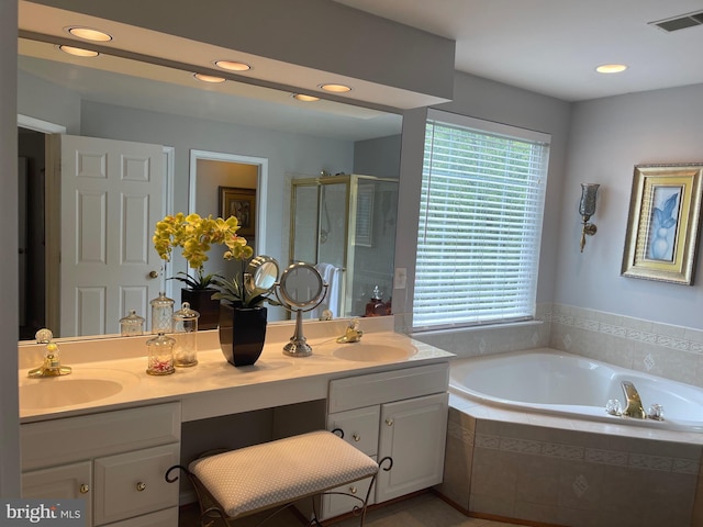 full bathroom with a sink, visible vents, a garden tub, and a shower stall