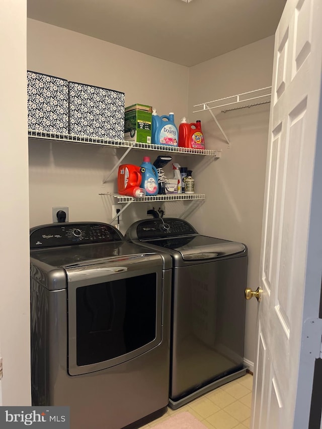 laundry area featuring laundry area, light tile patterned flooring, and washer and clothes dryer