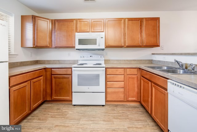 kitchen featuring sink, white appliances, and light hardwood / wood-style floors