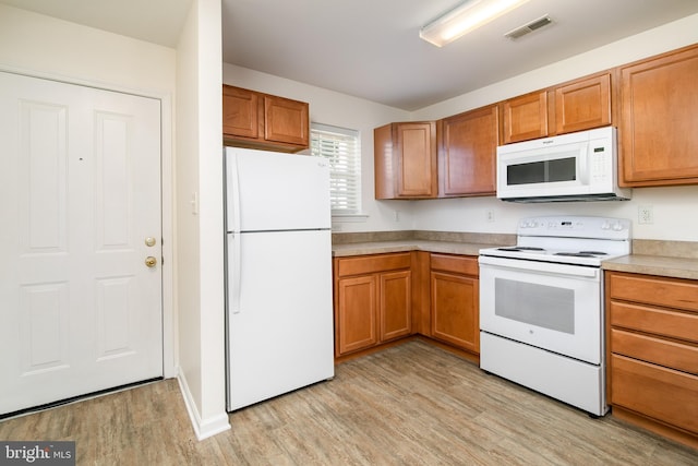 kitchen with white appliances and light hardwood / wood-style floors