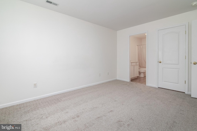 unfurnished bedroom with light carpet and ensuite bathroom