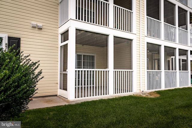 property entrance featuring a balcony and a lawn