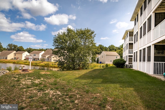 view of yard featuring a balcony, cooling unit, and a water view