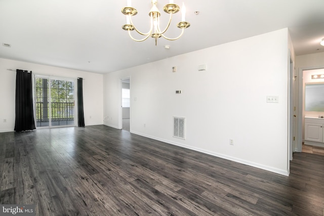 unfurnished living room with dark hardwood / wood-style floors and a notable chandelier