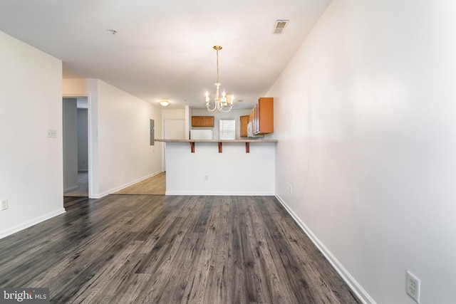 unfurnished dining area featuring a chandelier and dark hardwood / wood-style floors