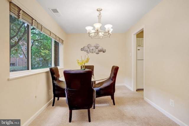 dining area with a chandelier and light carpet