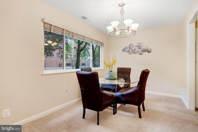 dining space featuring light colored carpet and a notable chandelier