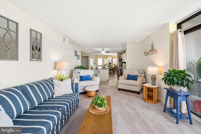 carpeted living room with a textured ceiling and ceiling fan